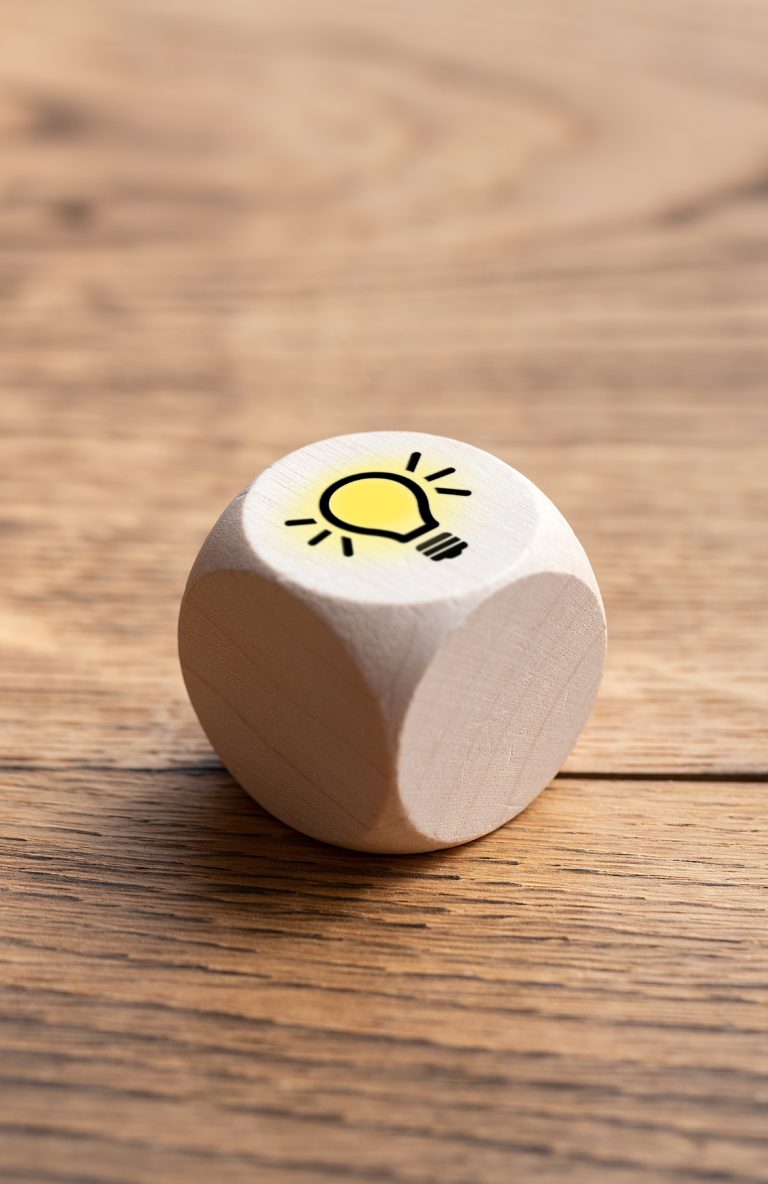 cube with a lightbulb symbol on wooden background